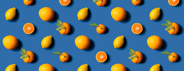 Citrus fruits pattern: mandarine, tangerine, oranges and lemons on blue background. Hard light.