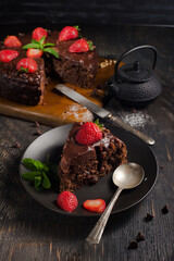 chocolate cake with strawberries on a black table