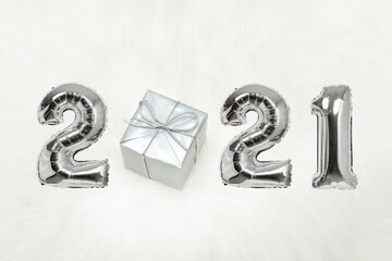 Number 2021 of silver balloons. Gift box. White background. New years concept