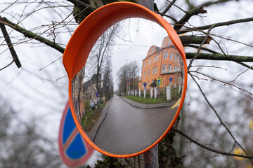 Reflection of a city street in an outdoor convex mirror.