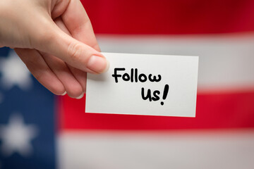 Follow us text on a card. American flag background.