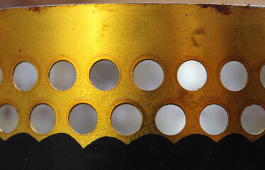 a gold old plate with two rows of circular holes. Gold background, vintage, background for...