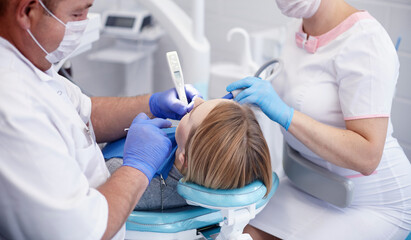 Doctor dentist treats teeth of a beautiful young girl patient. The girl on reception at the dentist. Doctor dentist treats tooth