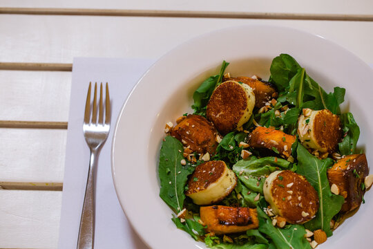 Plato de ensalada fresca con lechuga y semillas emplatado con tenedor