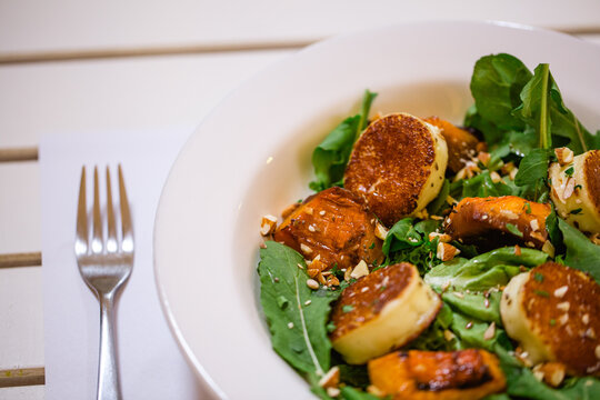 Plato de ensalada fresca con lechuga y semillas emplatado con tenedor