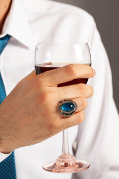 Blue silver ring and accessories on male finger in white shirt with blue tie.