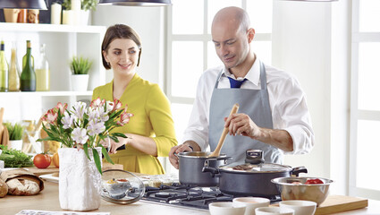 Smiling young couple cooking food in the kitchen