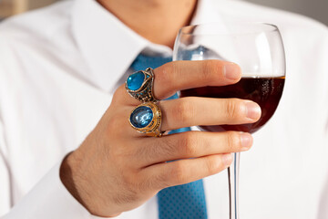Blue silver rings and accessories on male finger with blue tie in white shirt.