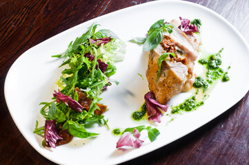 white chicken meat with herbs, a dish in a restaurant