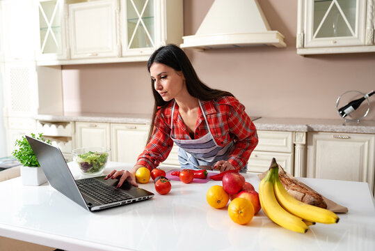 girl in the kitchen watching a recipe in a laptop