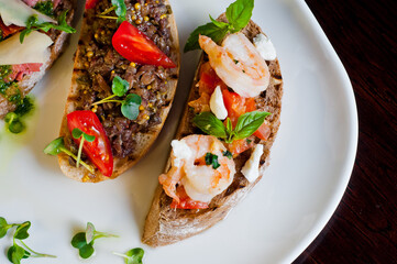 Bruschetta with herring,pate and meat on black wooden background. Close-up.
