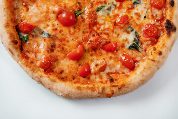 Italian pizza with tomatoes, spinach and cheese close-up. Italian fast food delivery.