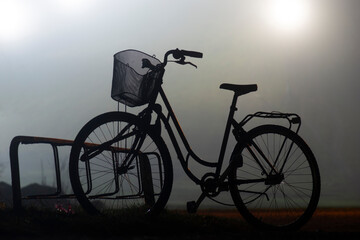 Fototapeta na wymiar Back lit silhouette of bike in bicycle stand