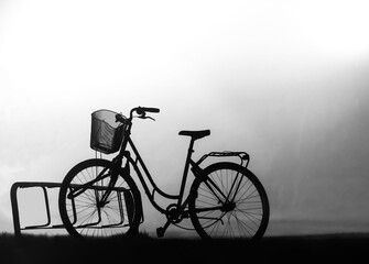 Fototapeta na wymiar Back lit silhouette of bike in bicycle stand