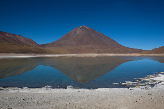 Reflections of mountains in the clear water of the Green Lake (Laguna Verde) on the Bolivian altiplano, Bolivia