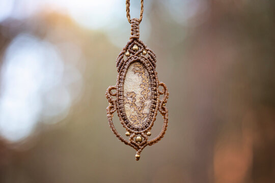 Mineral gemstone ornamental pendant on blury forest background