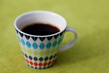hot coffee in beautiful cup standing on green picnic fabric in nature in Umea