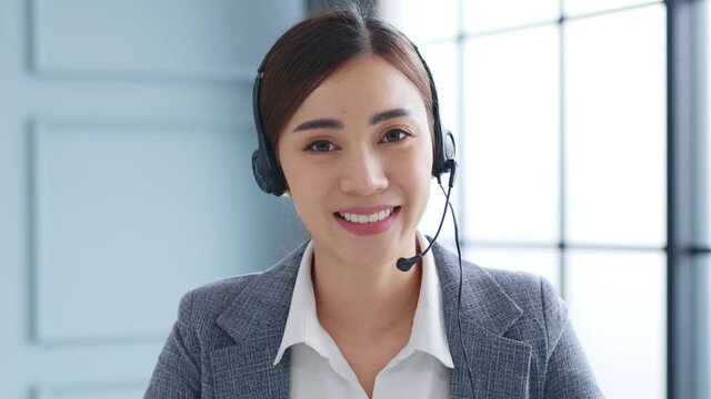 POV Young Asian businesswoman, call center, customer service talking on video call conference or virtual meeting in office, front view, look at camera