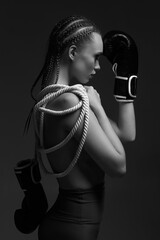 fashion sexy gorgeous woman model with black boxing gloves and white rope on studio background. Glamour female boxer portrait. black and white