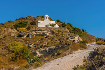 Fototapeta premium A view of a church from the path on the Caldera rim in Santorini in summertime