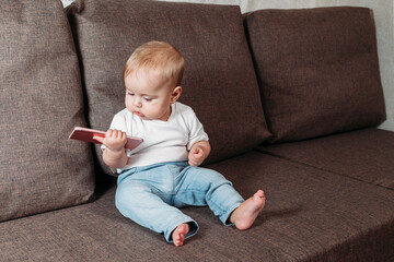 cute baby boy playing with mobile phone closeup