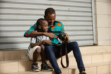 young father and his son looking at pictures on a camera