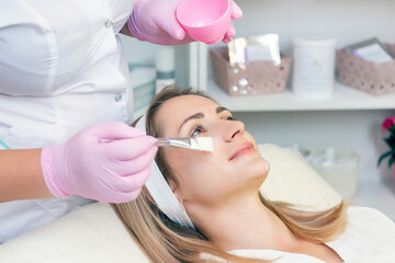 cosmetology. young woman with receiving facial cleansing procedure in beauty salon.