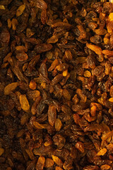 A large number of dark brown long raisins