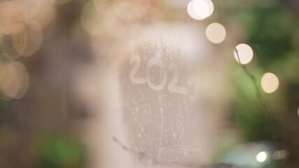 85mm view of lettering 2021 written on foggy display window of shopping mall - Powered by Adobe