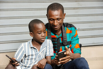 young father and his son using a mobile phone