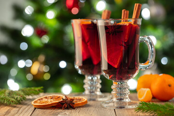 Two glass of christmas mulled wine or gluhwein with spices and orange slices on rustic table...