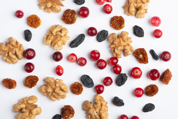 Dried cranberries, walnuts, raisins, on white background.