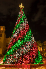 Holiday Christmas. Christmas tree decorated with red, green and white lights at the night time.