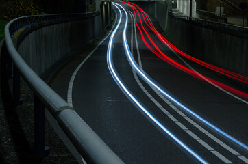 curved light trails from car lights across the road
