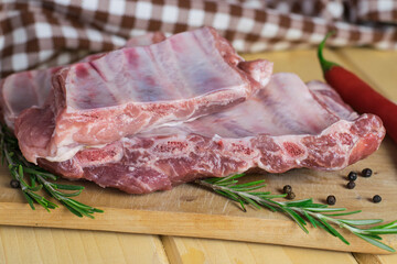 Uncooked pork ribs on a wooden board. Raw pork ribs close up.