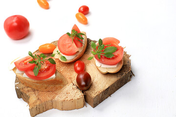 Caprese and Toast bruschetta with mozzarella cheese, cherry tomatoes and fresh garden basil. Traditional Italian food, healthy natural breakfast, cholesterol and GMO free, space for text,