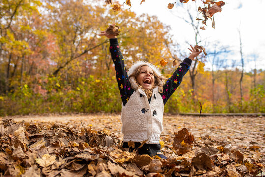 Young girl enjoying fall and leaves