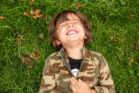 Little boy laughing on green grass