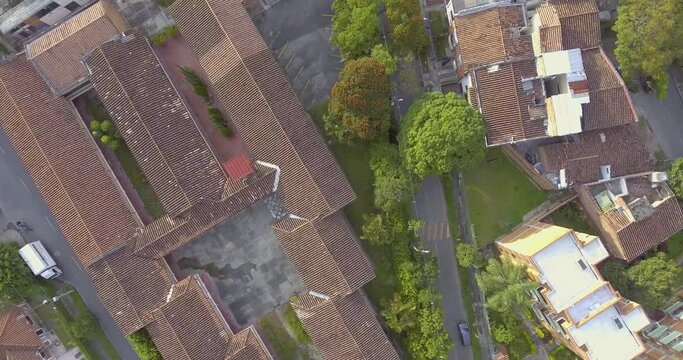 Large Colonial House Rooftops with Lots of Trees Around on a Cloudy Day