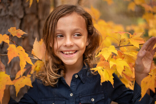 Young girl standing in some fall leaves