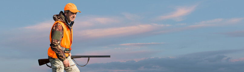 Silhouette of a hunter with a gun against the sun, an ambush for ducks.