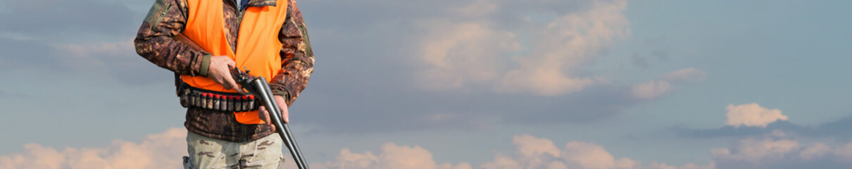 Silhouette of a hunter with a gun against the sun, an ambush for ducks.