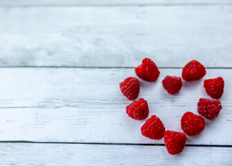 raspberry heart on the white wooden table