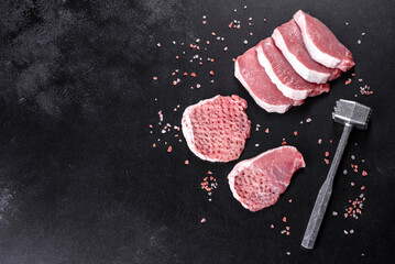 A fresh raw piece of pork escalop cut into several parts