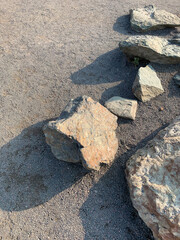 Fototapeta na wymiar Group of stones with shadows on fine gravel