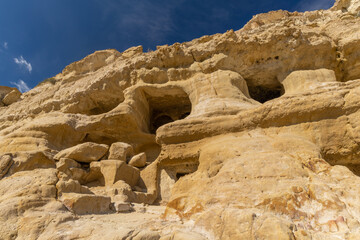 Fototapeta premium Stunning Roman catacombs carved on the sandstone cliffs above the Matala Beach, Crete, Greece. In Roman times, the dead were buried in them, later they were used by the first Christians