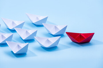 Red and white paper boats. Concept of leadership boats for teamwork group or success.
