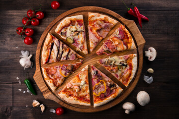 different pizza slices on a round wooden Board