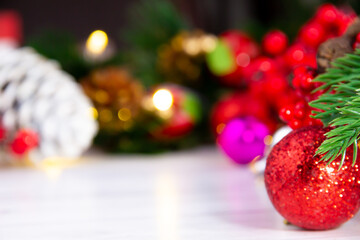 bright red christmas ball standing in front of pine tree light and various christmas decorations
