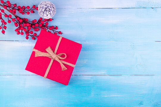 New Year Background! Red christmas gift box and cone on blue wood background